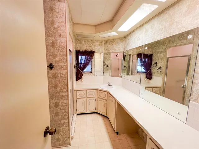 a spacious bathroom with a sink a mirror and shower