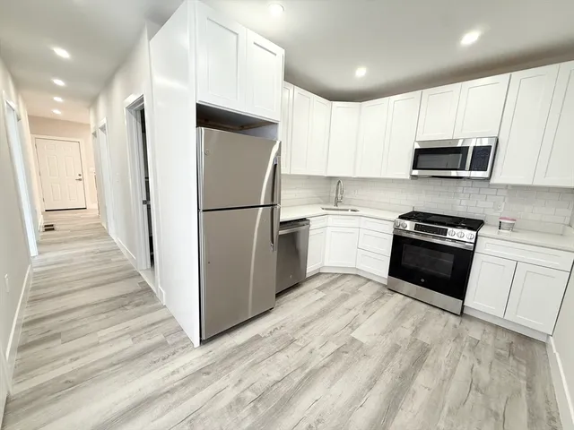 a kitchen with white cabinets and stainless steel appliances