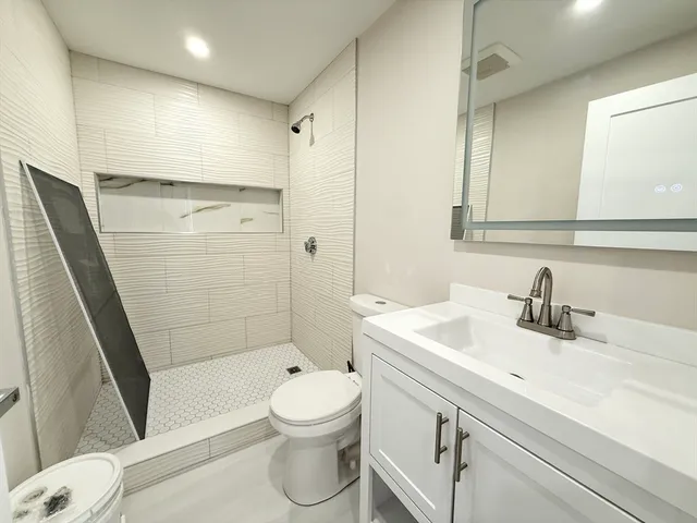 a bathroom with a sink a toilet and shower