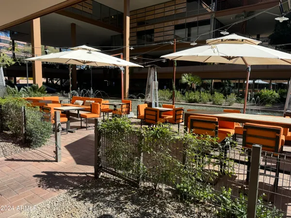 a view of patio with chairs and table under an umbrella
