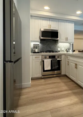 a kitchen with stainless steel appliances granite countertop a stove a sink and a microwave