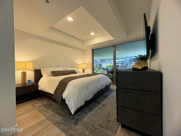 a bedroom with a bed window and dresser