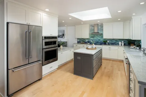 a kitchen with a sink a counter top space stainless steel appliances and cabinets