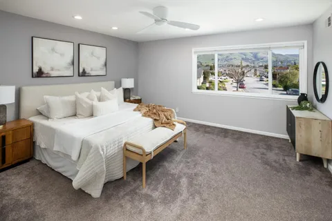 a bedroom with a bed a couch and a window