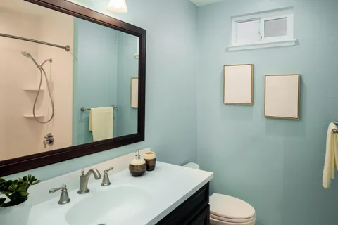 a bathroom with a sink vanity mirror and toilet