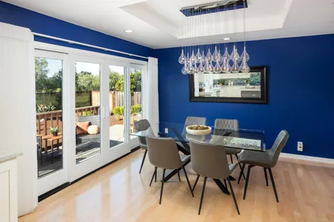 a view of a dining room with furniture large window and wooden floor