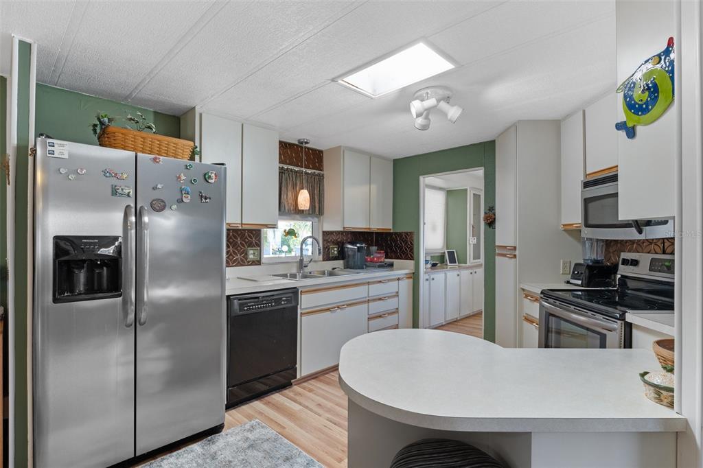 175 Martinique Road North Port, FL 34287 - Photo 3 of 82 a kitchen with stainless steel appliances granite countertop a refrigerator a sink a stove and chairs