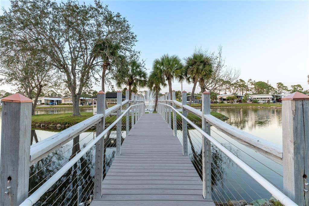 175 Martinique Road North Port, FL 34287 - Photo 48 of 82 a view of a lake with wooden stairs and large trees