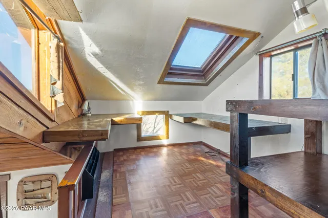 a front view of a house with barbeque and wooden fence