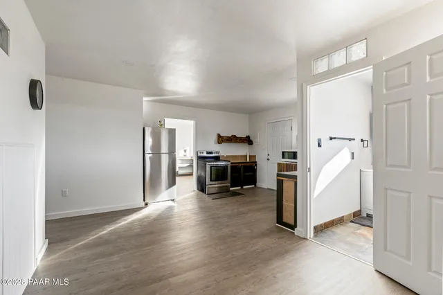 a view of a livingroom with a kitchen and a refrigerator