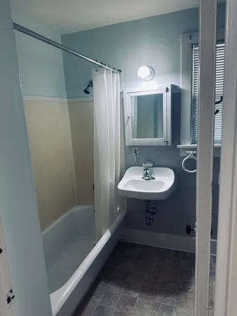 a bathroom with a sink a mirror a bathtub and shower