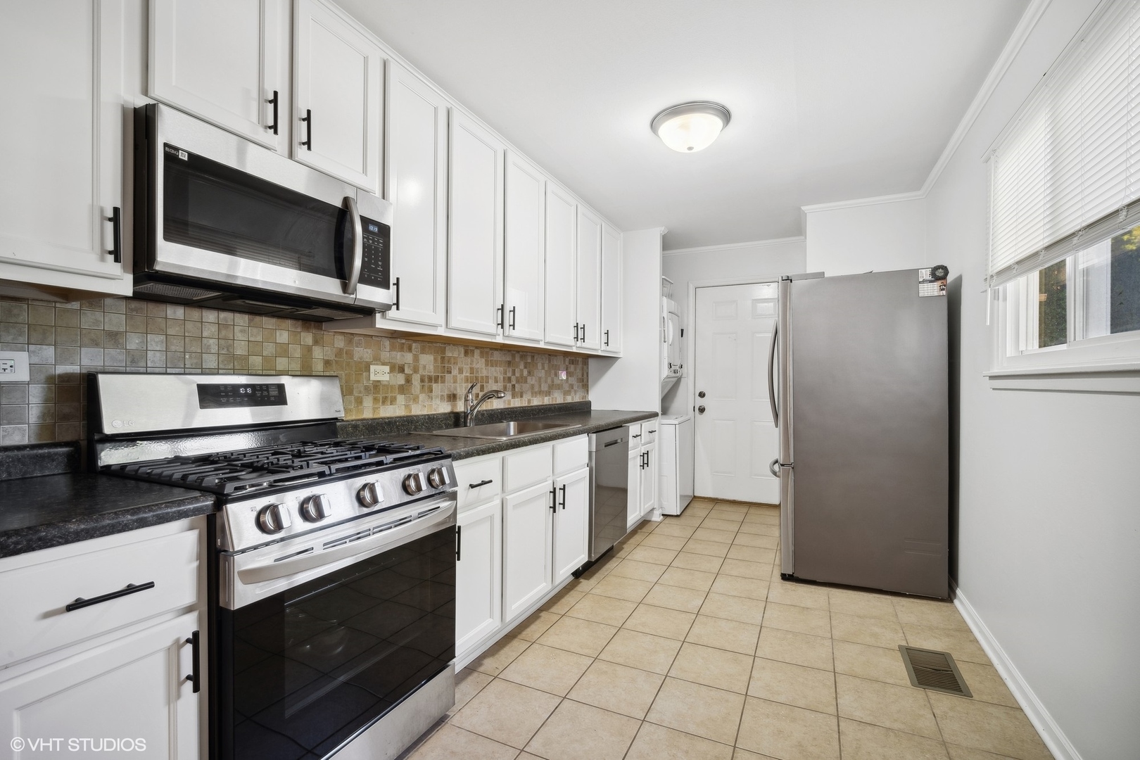 321 East Dennis Road Wheeling, IL 60090 - Photo 8 of 15 a kitchen with stainless steel appliances granite countertop a stove a refrigerator and a microwave