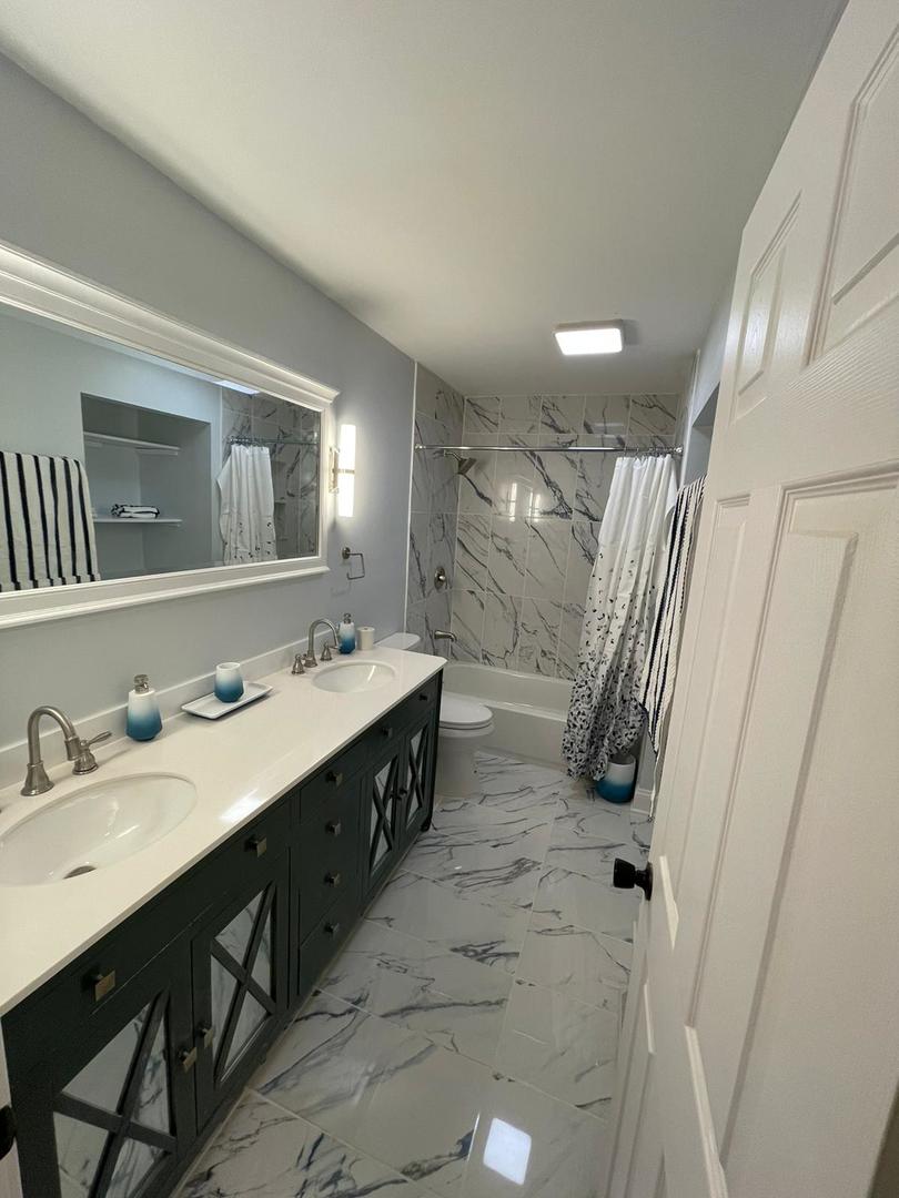 725 North Rohlwing Road Palatine, IL 60074 - Photo 16 of 27 a spacious bathroom with a double vanity sink a mirror and a shower