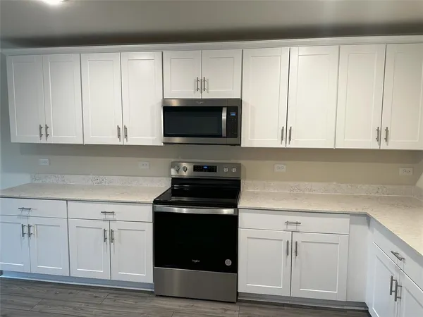 a kitchen with white cabinets and black appliances