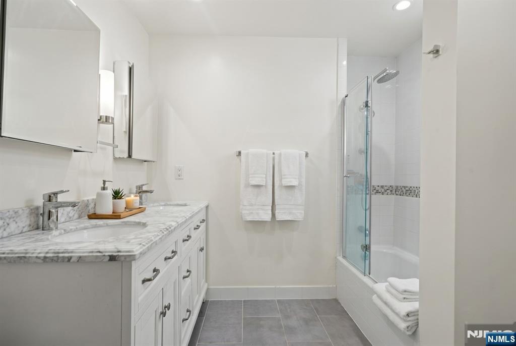 436 Undercliff Avenue Edgewater, NJ 07020 - Photo 12 of 33 a bathroom with a granite countertop sink a toilet and shower