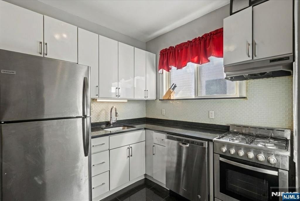 436 Undercliff Avenue Edgewater, NJ 07020 - Photo 16 of 33 a kitchen with stainless steel appliances granite countertop a refrigerator sink stove and cabinets