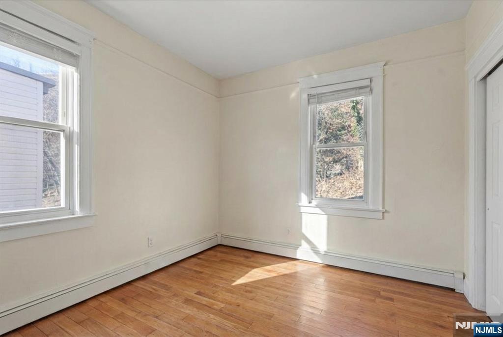 436 Undercliff Avenue Edgewater, NJ 07020 - Photo 19 of 33 an empty room with wooden floor and windows