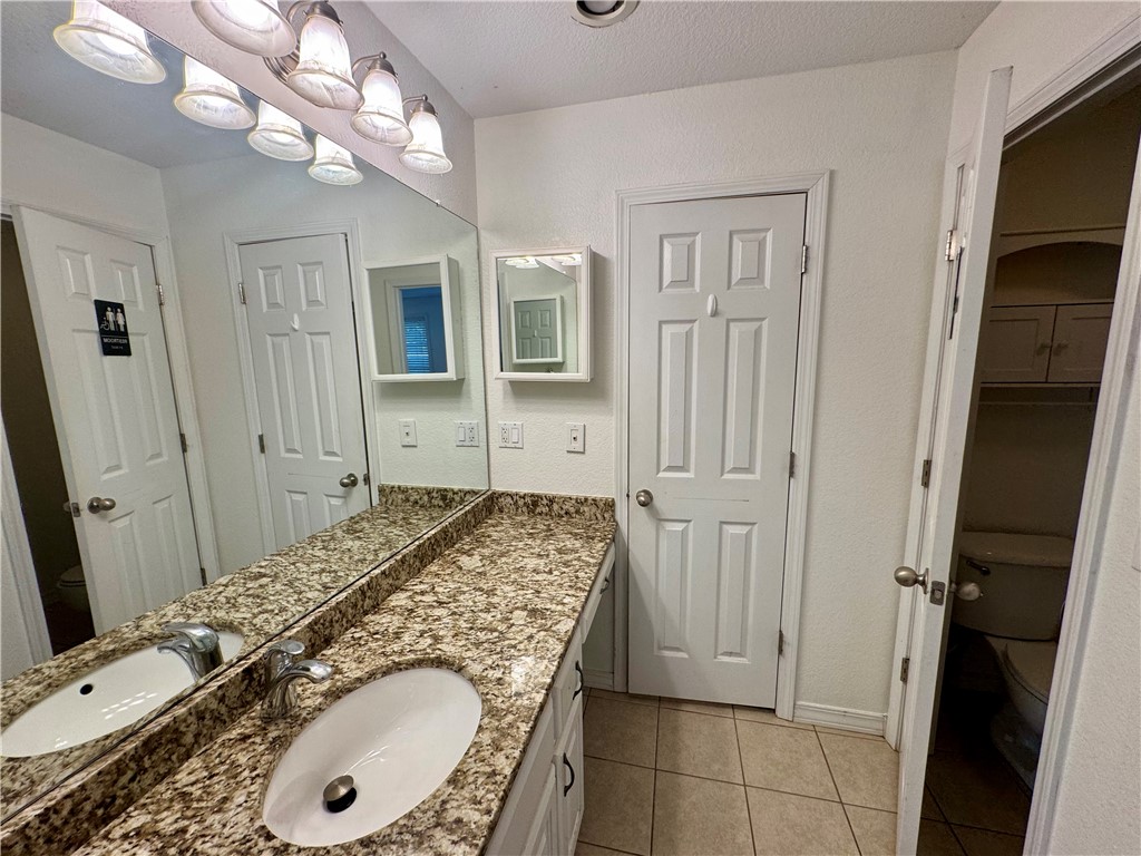 1197 Ridgeview Lane Russellville, AR 72802 - Photo 24 of 44 Bathroom vanity featuring a speckled countertop, dual undermount sinks, and a full-width mirror