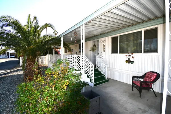 a view of a house with backyard and sitting area