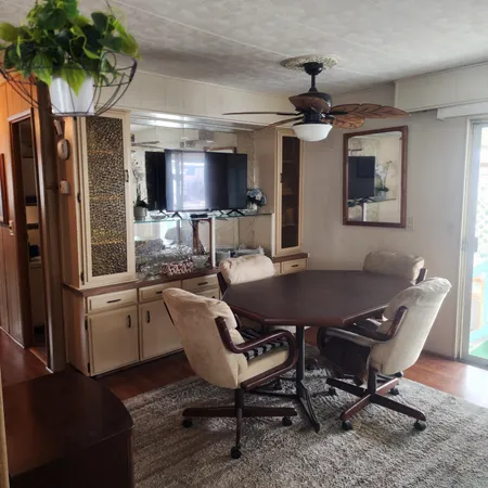 a living room with furniture a chandelier and a dining table