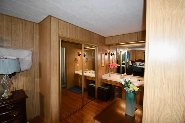 a room with lots of wooden furniture and a view of living room