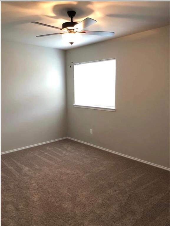 1207 Garland Road Georgetown, TX 78626 - Photo 7 of 10 an empty room with a chandelier fan and windows
