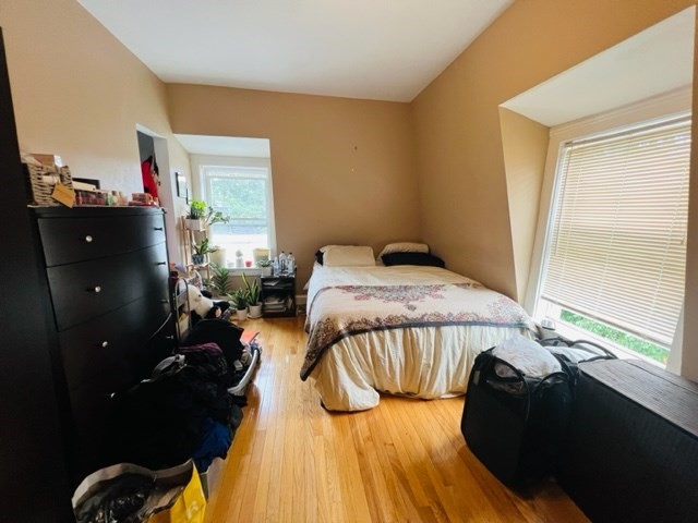 9 Rice Street, Unit 5 Brookline, MA 02445 - Photo 2 of 8 a bedroom with a bed and wooden floor