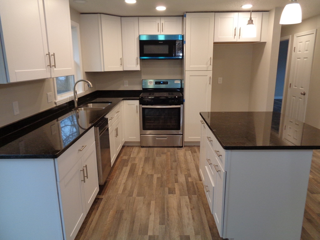 33 Hally Road Lowell, MA 01854 - Photo 6 of 19 a kitchen with stainless steel appliances granite countertop a sink and a stove