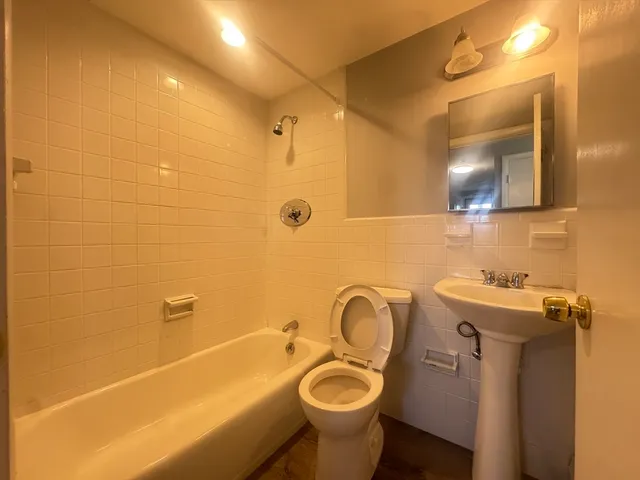 a bathroom with a sink a toilet and mirror