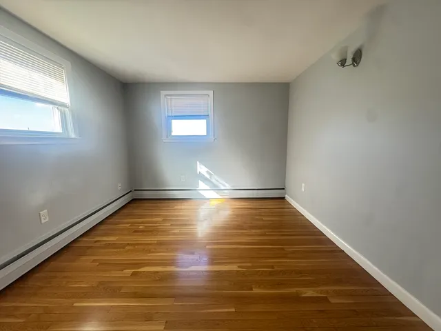 a view of room with window and wooden floor
