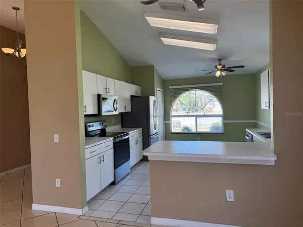 a kitchen with stainless steel appliances a sink a stove top oven a counter space and cabinets