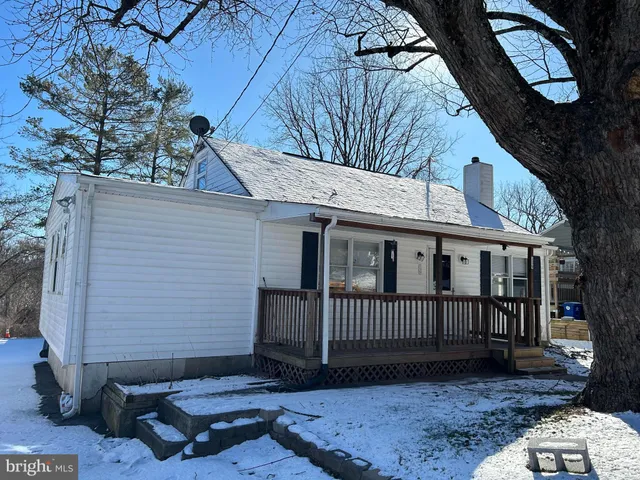 a view of a house with a wooden deck and a backyard