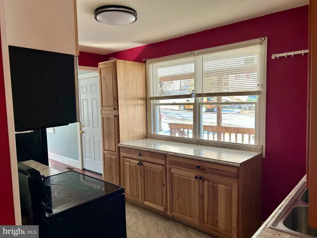 a kitchen with a sink a large window and wooden cabinets