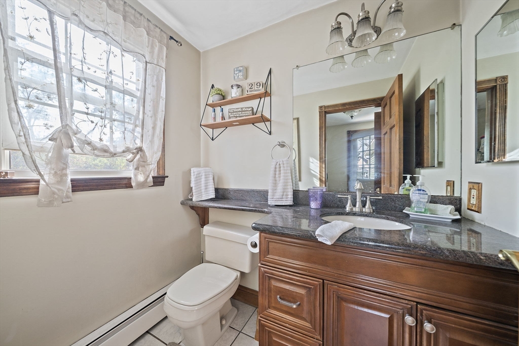 164 Hancock Street Abington, MA 02351 - Photo 12 of 42 a bathroom with a granite countertop toilet sink and mirror