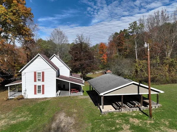 a view of a big house with a big yard and large trees