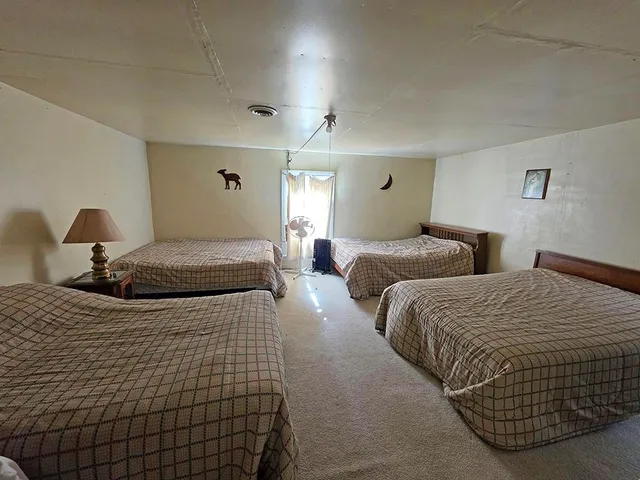 a bedroom with a bed and painting on the wall