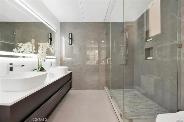 a bathroom with a double vanity sink toilet and shower