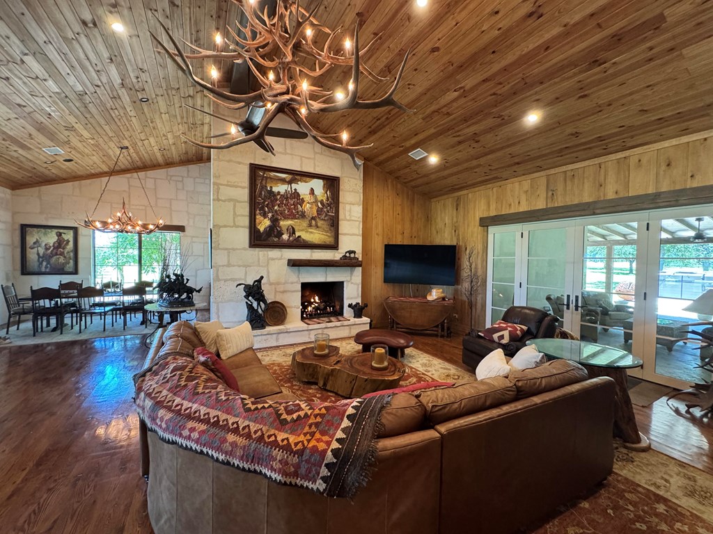 772 Luckenbach Road Fredericksburg, TX 78624 - Photo 11 of 87 a living room with furniture a fireplace and a flat screen tv
