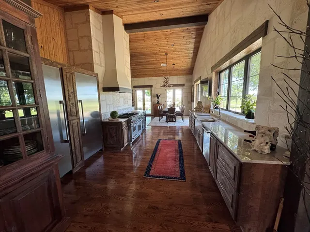 a kitchen with a large stove a sink dishwasher and a dining table with granite countertop