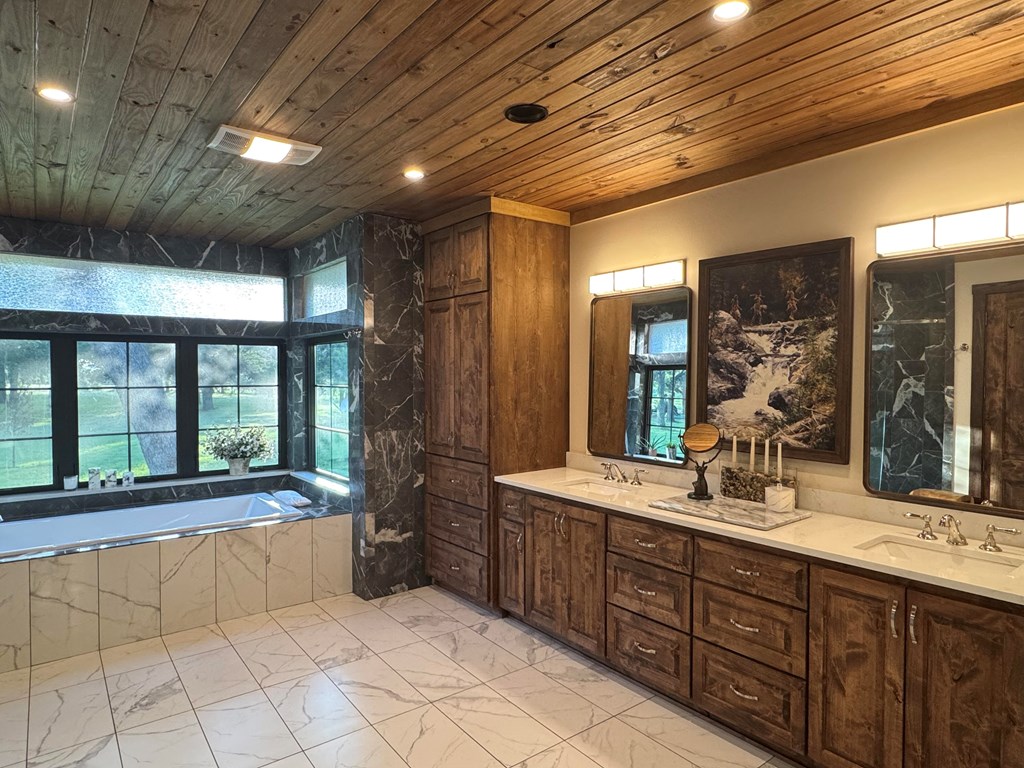 772 Luckenbach Road Fredericksburg, TX 78624 - Photo 33 of 87 a bathroom with a large tub sink shower and double vanity