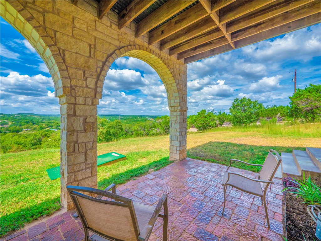 a view of a patio with a table and chairs under an umbrella