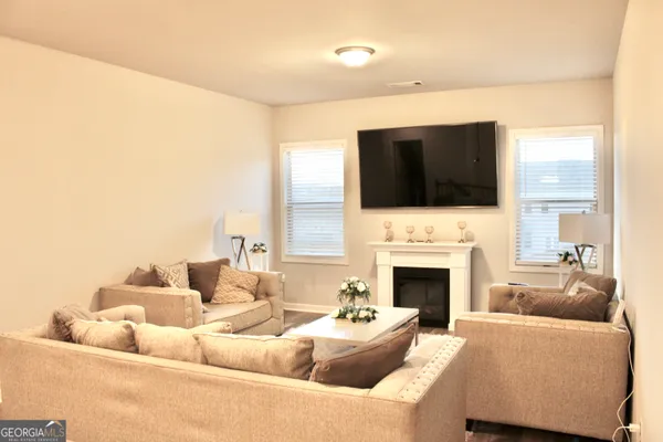 a living room with furniture a fireplace and a flat screen tv