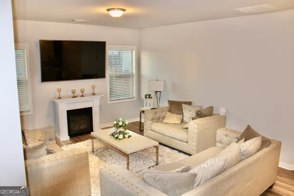 a living room with furniture a fireplace and a flat screen tv
