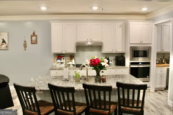 a dining room with furniture and kitchen view