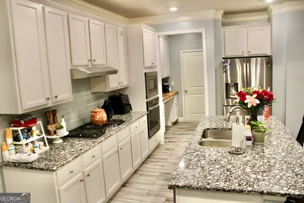 a kitchen with white cabinets and sink