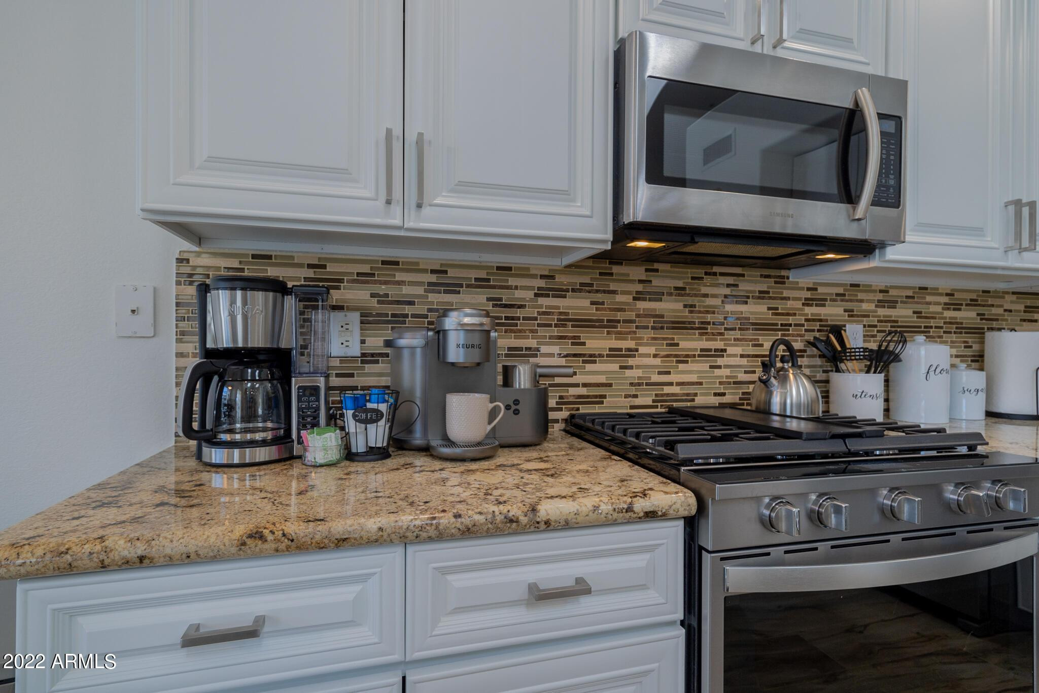 8661 East Gail Road Scottsdale, AZ 85260 - Photo 19 of 49 a kitchen with granite countertop a stove and a microwave