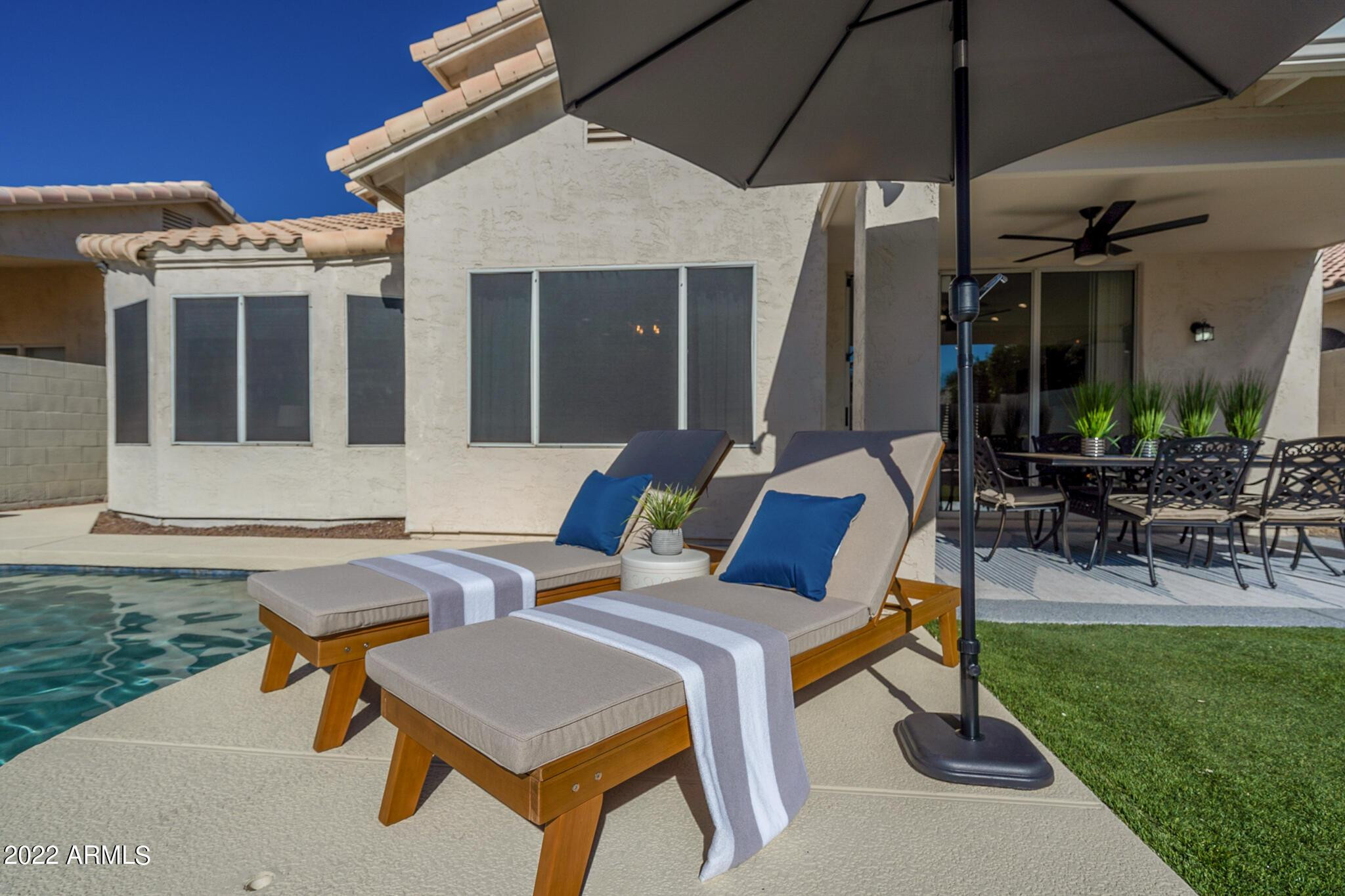 8661 East Gail Road Scottsdale, AZ 85260 - Photo 2 of 49 a view of a patio with couches table and chairs under an umbrella