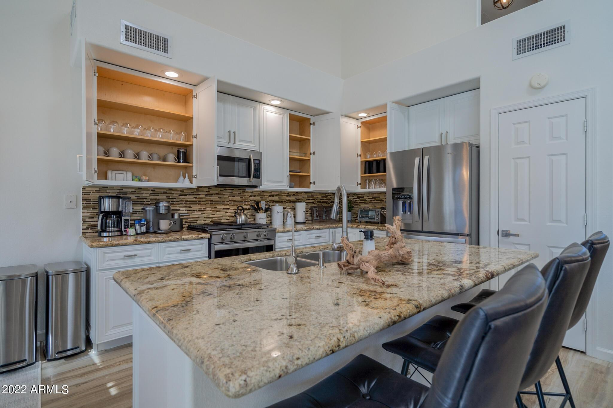 8661 East Gail Road Scottsdale, AZ 85260 - Photo 21 of 49 a kitchen with stainless steel appliances granite countertop a table chairs sink refrigerator and microwave