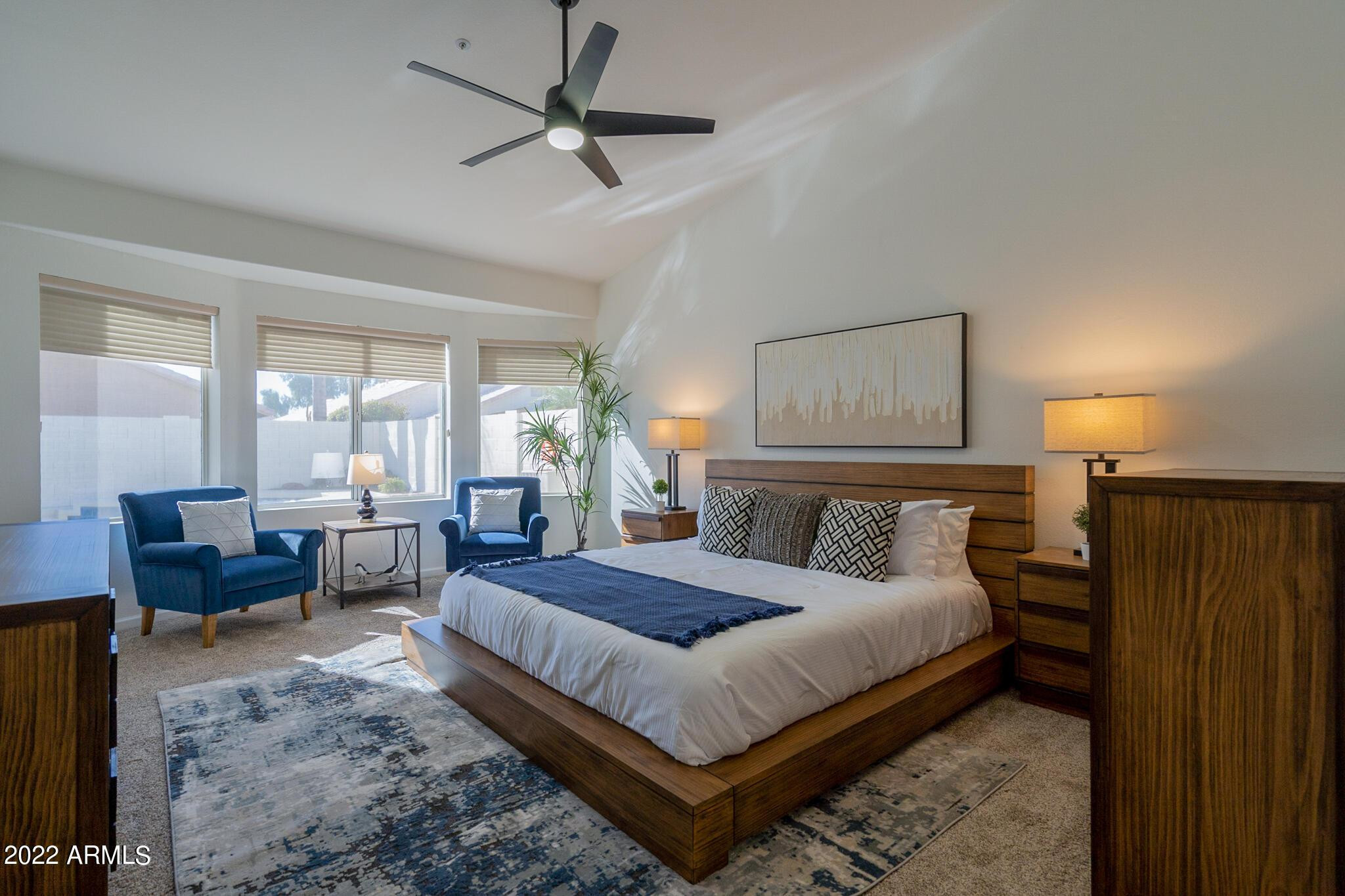 8661 East Gail Road Scottsdale, AZ 85260 - Photo 8 of 49 a bedroom with a large bed a chandelier and a window