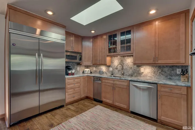 a kitchen with stainless steel appliances granite countertop a refrigerator and white cabinets